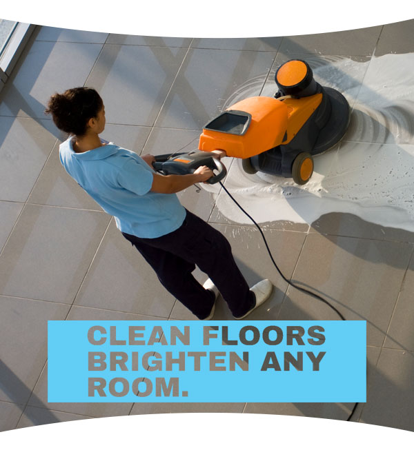 professional cleaner runs a floor machine to clean commercial flooring.